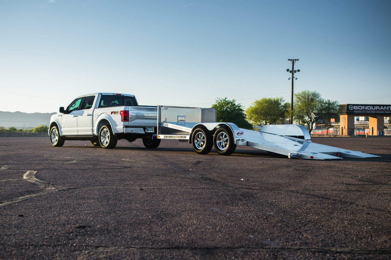 Jimglo Ego Tilt Bed Trailer With The Bed Down Behind A White Ford F150